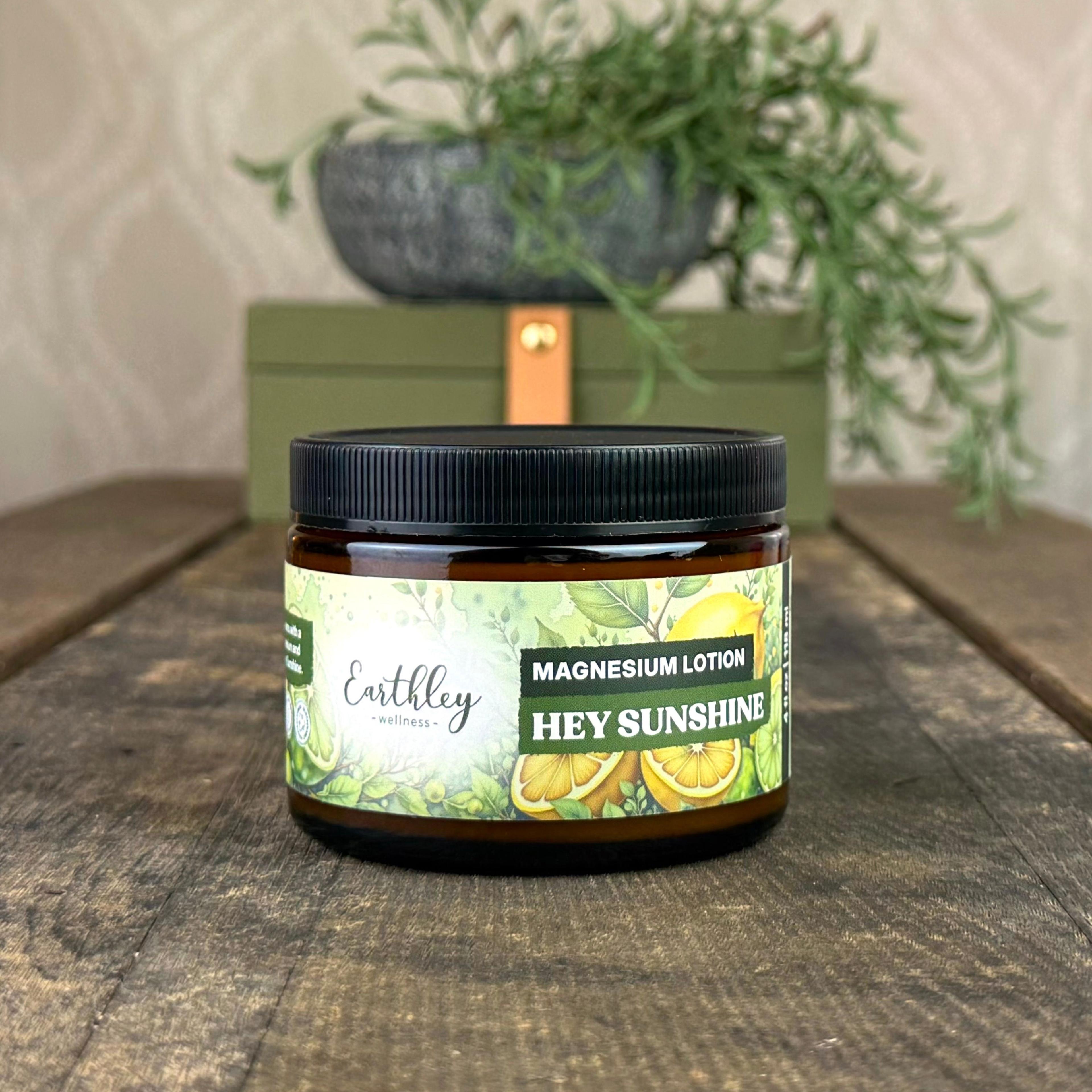 Earthley Hey Sunshine Magnesium Lotion jar with botanical citrus label on wooden surface with green plant decor