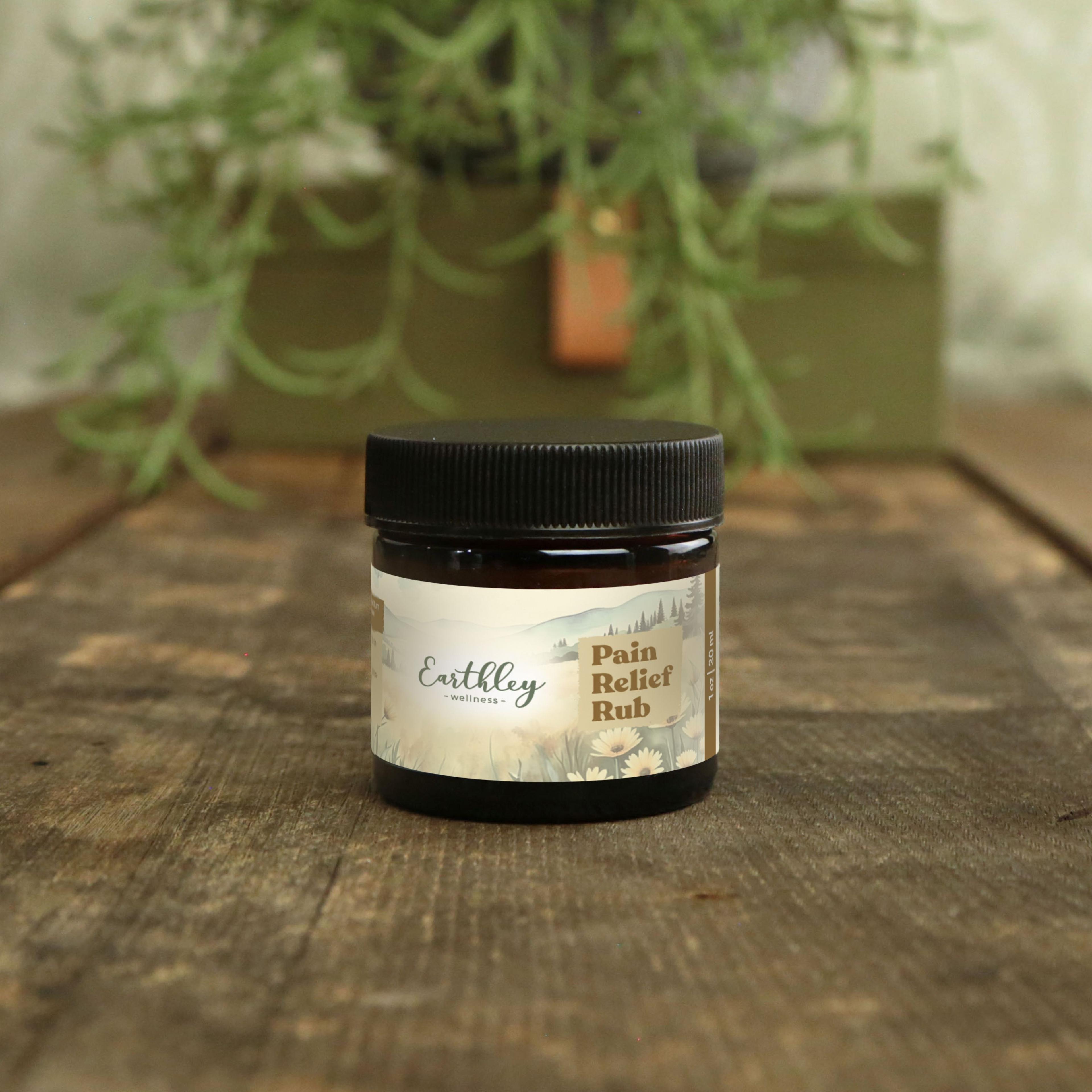 Earthley Wellness Pain Relief Rub in small amber jar with black lid on wood surface