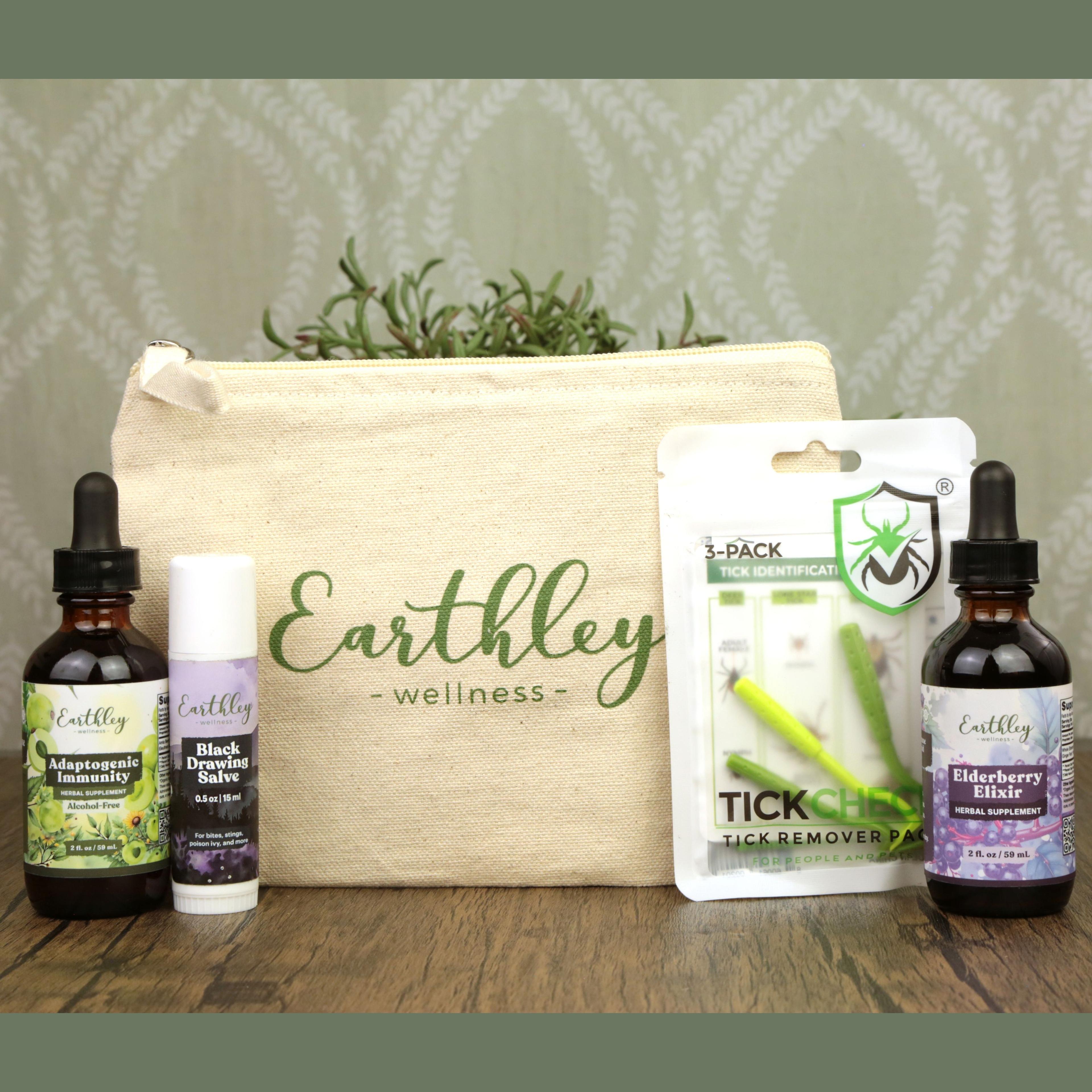 Earthley Wellness canvas bag with herbal products: Adaptogenic Immunity tincture, Black Drawing Salve, Tick Gone remover pack, and Elderberry Elixir