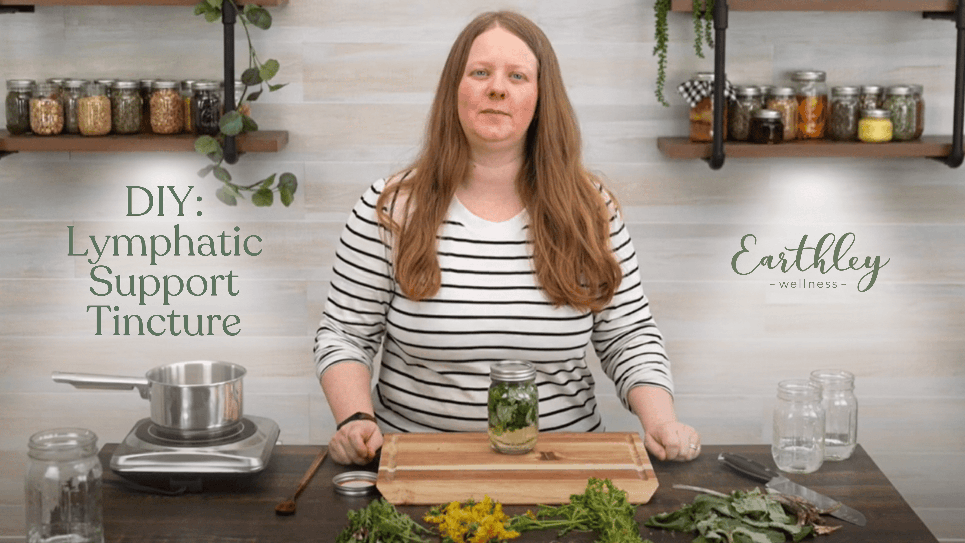 DIY Lymphatic Support Tincture video thumbnail showing woman with reddish-brown hair in front of black metal shelving with glass jars of dried herbs and gray white wall