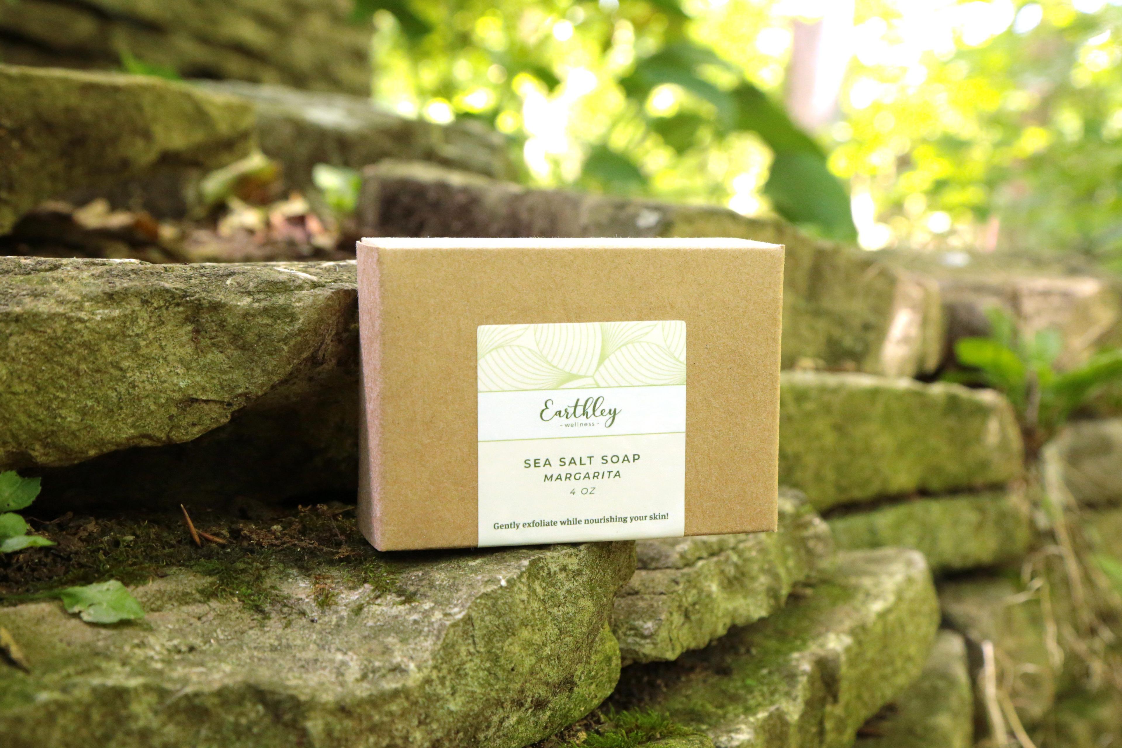 Sea Salt Soap in Margarita scent in kraft box with green leaf label on moss-covered stone steps in garden